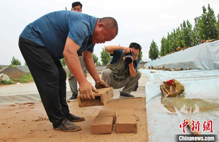 临清贡砖烧制技艺市级非遗传承人展示贡砖加工工序。 赵晓 摄