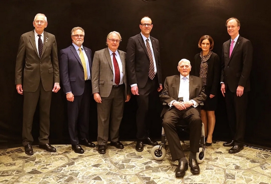 图上右三和左三分别为美国科学家约翰·古迪纳夫和斯坦利·惠廷厄姆，他们和日本科学家吉野彰一起因为在锂离子电池研发领域作出的贡献获得了2019年诺贝尔化学奖