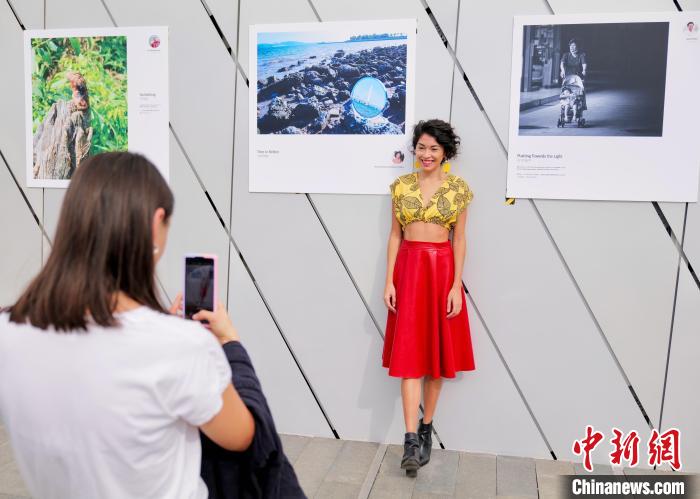 图为参赛选手与自己的摄影作品同框留影。陈文 摄