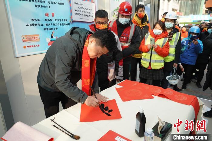 多位著名书法家现场为在京劳模代表和一线职工书写春联和“福”字。　王鑫 摄