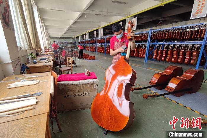 图为河南省确山县的提琴企业里工人在忙于制作提琴。李超庆 摄