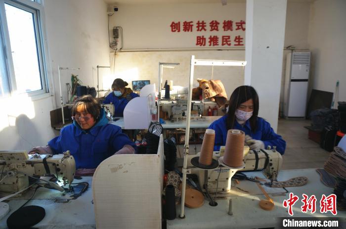 河南省辉县市西平罗乡兆村的一个扶贫就业车间里，女工们正在加工鞋垫。韩章云 摄