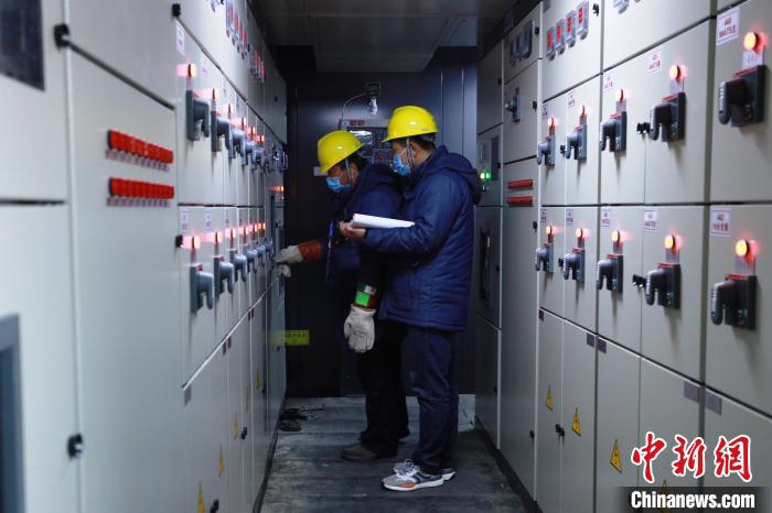 图为颁奖广场电力保障团队成员在北京颁奖广场设备区进行大负荷试验前操作。张博宁 摄