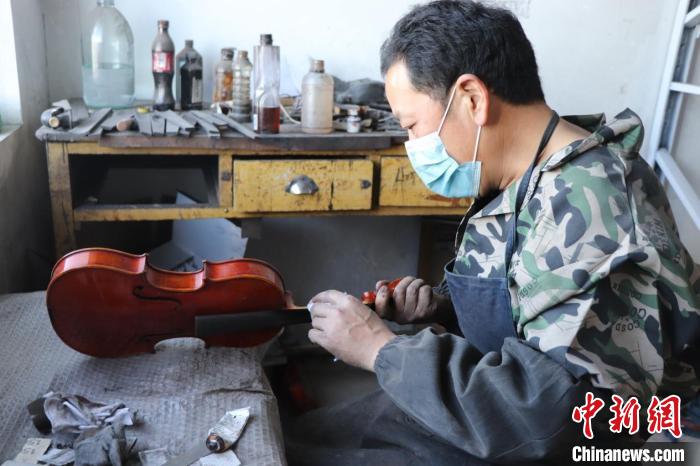 图为河北省大城县八方村村民为提琴上漆。　张艺典 摄