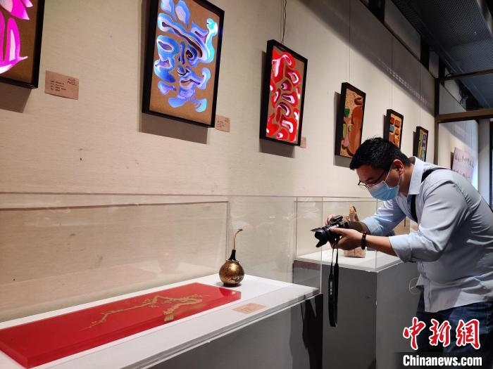图为：“重塑|福州大漆与软木设计成果展”展览现场，游客正在拍照。　叶秋云 摄