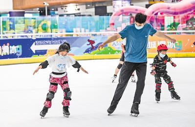 7月26日，在石家庄天山海世界滑冰场，小学员在教练的指导下练习花样滑冰基本技术。 河北日报记者 耿 辉摄