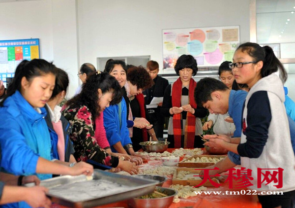 老师和学生们一起包饺子。