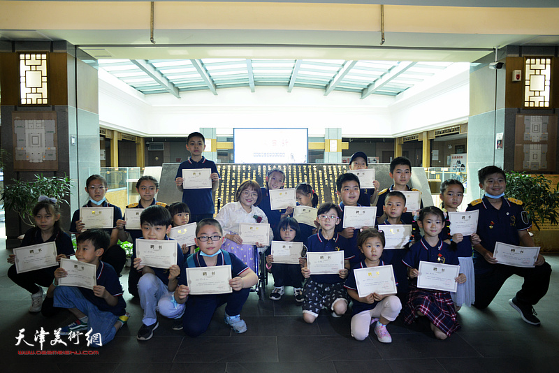 潮汐济困负责人玉芳老师向捐赠义卖作品的小画家颁发慈善证书。