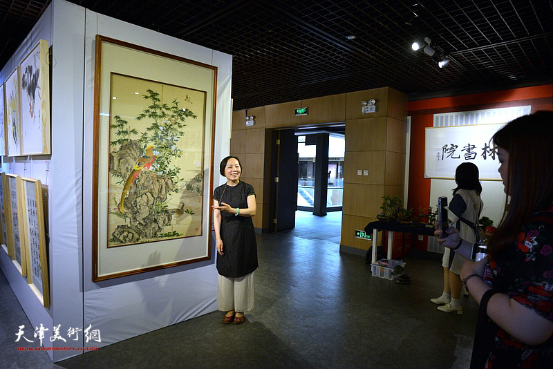 参展的画家在“时敏日新”师生作品展现场。