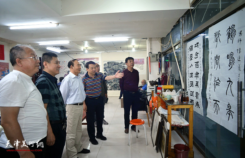 书法家孟新民向来宾介绍展出的陈连羲书画作品。