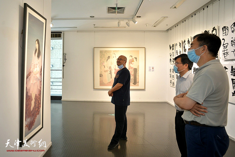 靳风辉、李鑫、于小冬在展览现场观看作品。