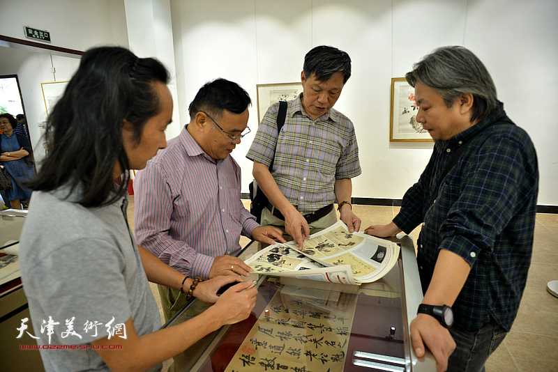孟庆祥、李泓伯、田正宪、安士胜在画展现场观看作品。