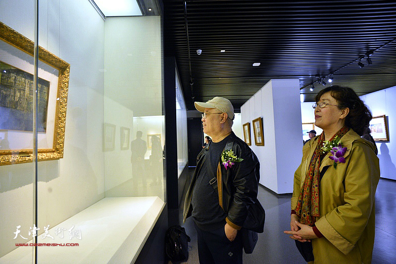 赵国经、王美芳在画展现场观看作品。