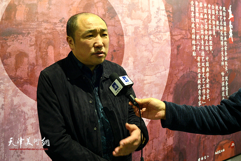卢禹舜在画展现场接受媒体采访。