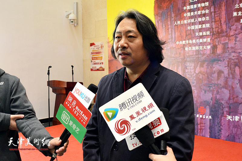 贾广健在画展现场接受媒体采访。