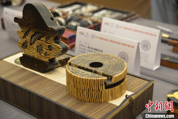 图为富含海南椰雕特色手机架作品。　符宇群 摄