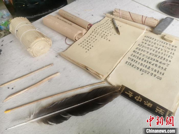 卢拉伙誊抄彝族毕摩经文时使用的书写工具和纸张。 起钰婷 摄