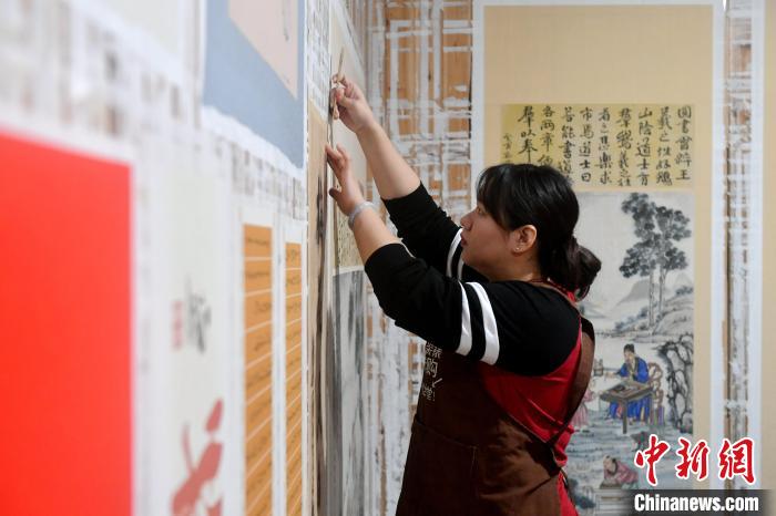 图为：陈雨正在拆画。　吕明 摄