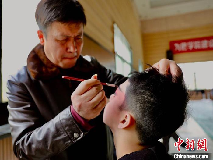 南充川剧非遗传习班老师为学员化妆。 杨波 摄