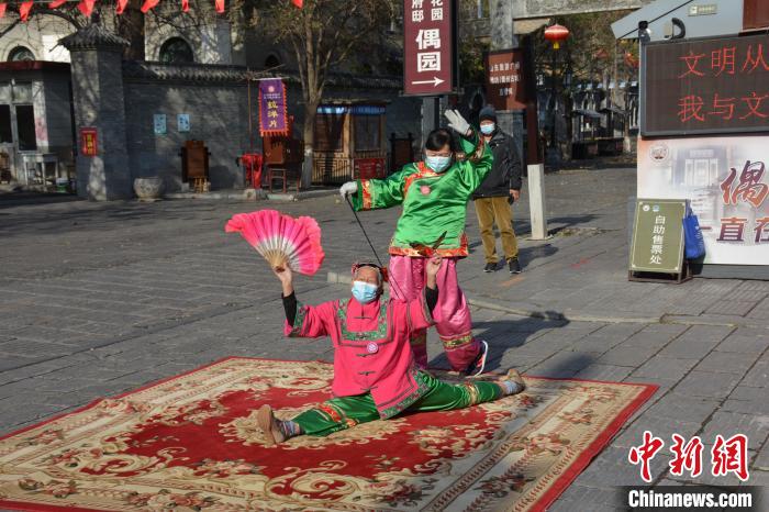 “扑蝴蝶”非遗传承人在青州偶园大街两侧表演传统技艺。 吕妍 摄
