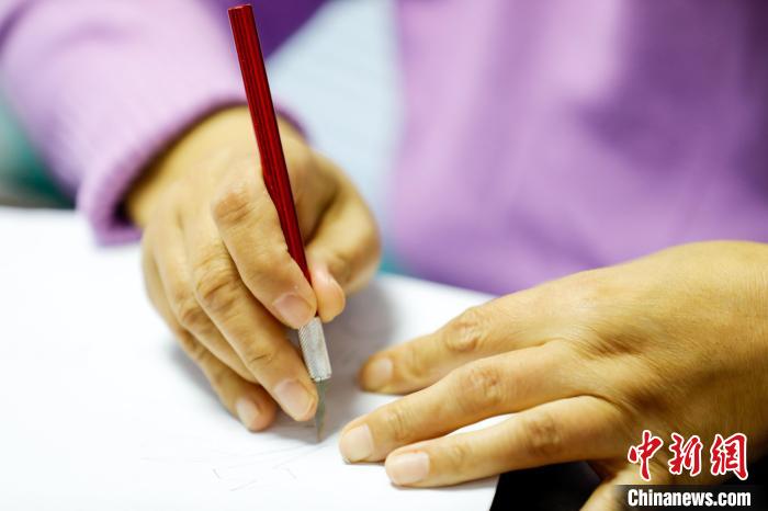 图为河北省大厂民间刻纸艺人张翠梅正在创作冬奥主题刻纸作品。　刘亮 摄