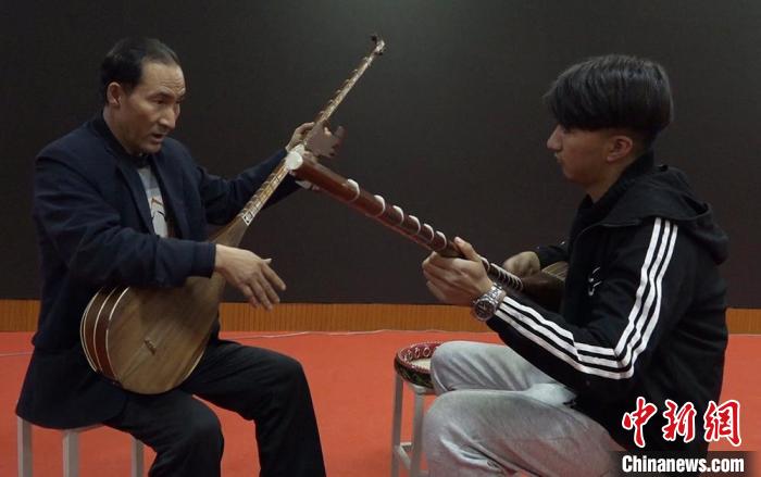 阿山·依米尔为喜欢都塔尔等乐器的青少年进行培训。 储旭 摄