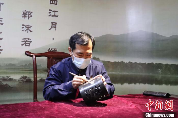 手工艺人雕刻黑陶。 李明芮 摄