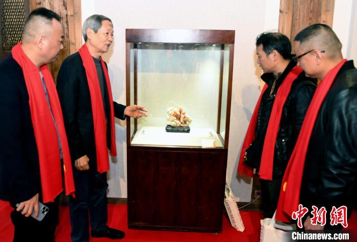 叶子贤(左二)向来宾介绍其参展寿山石雕作品创作构思。　记者刘可耕 摄