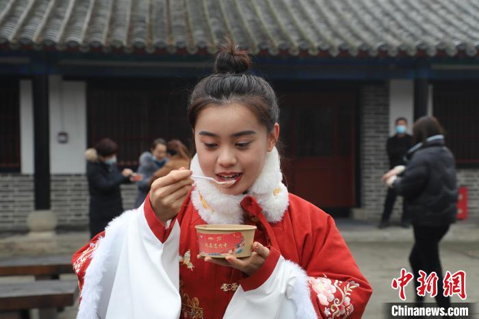 游客品尝热气腾腾的腊八粥。 刘鸿儒 摄