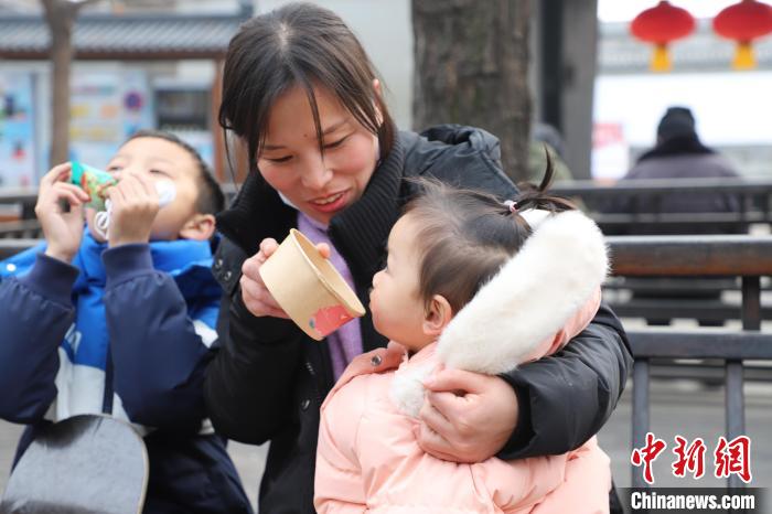 孩童品尝刚刚熬制出锅的腊八粥。 刘鸿儒 摄