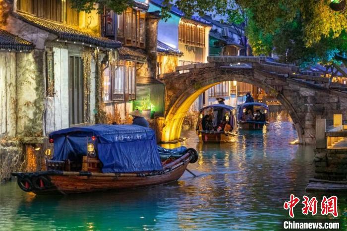游客乘坐江南传统的乌篷船穿梭于古镇周庄之中。(资料图) 袁菊明 摄