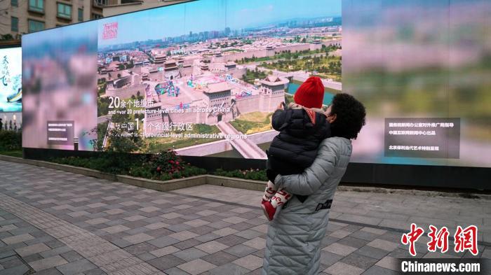 行人驻足观看《万象中国》预告片 吕心泉 摄
