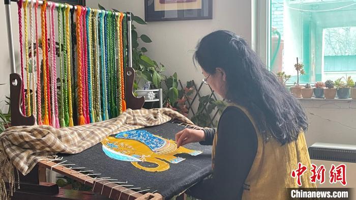 武俊敏根据图稿进行刺绣。　杨静 摄