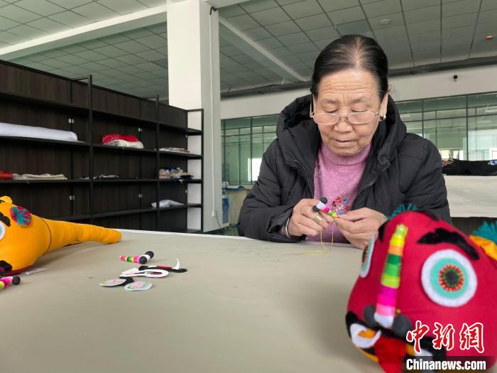 图为现年60岁的绣娘席金莲正在制作绣品。　祁绣娟 摄