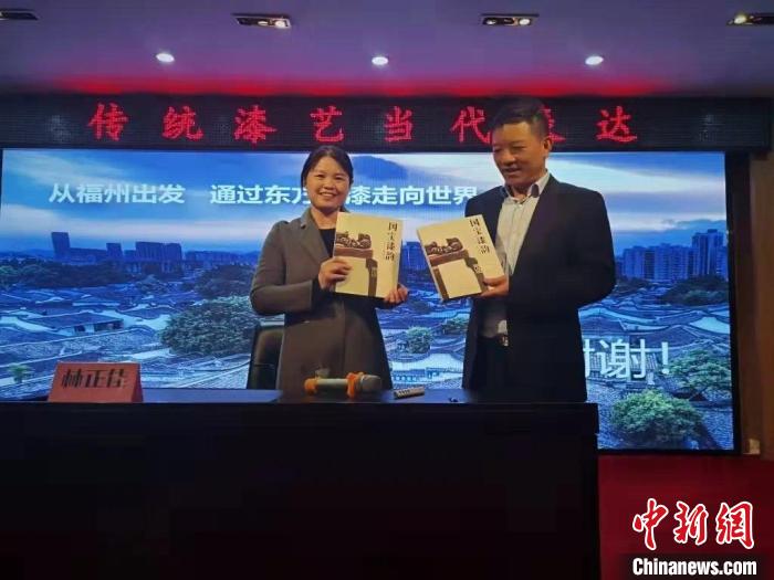 福建省文学院院长钟红英接受嘉宾赠送书籍《国宝漆韵》。　缪罗建 摄