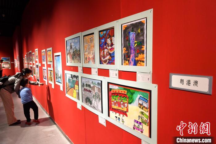 图为家长带着孩子参观展览。　吕明 摄