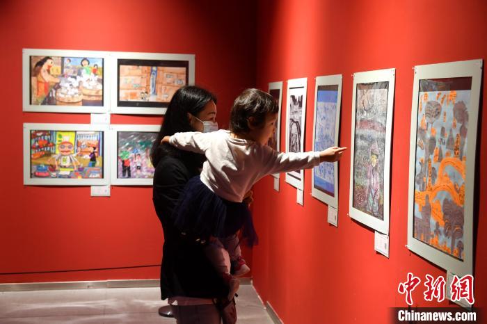 图为家长带着孩子参观展览。　吕明 摄