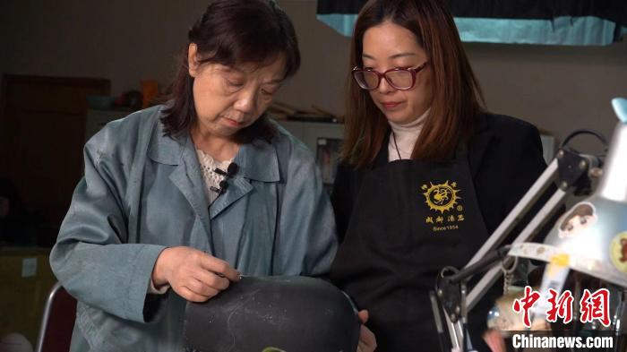 尹利萍(左)正在指导徒弟制作漆器。　 郜兴龙 摄