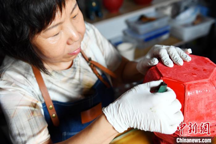 图为许晓芳在工作台前对工艺品半成品进行打磨。 孙宝宇 摄