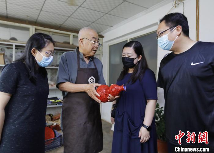 在河北省固安县南宋村,雕漆匠人朱庆元向来宾介绍漆器作品。 门丛硕 摄