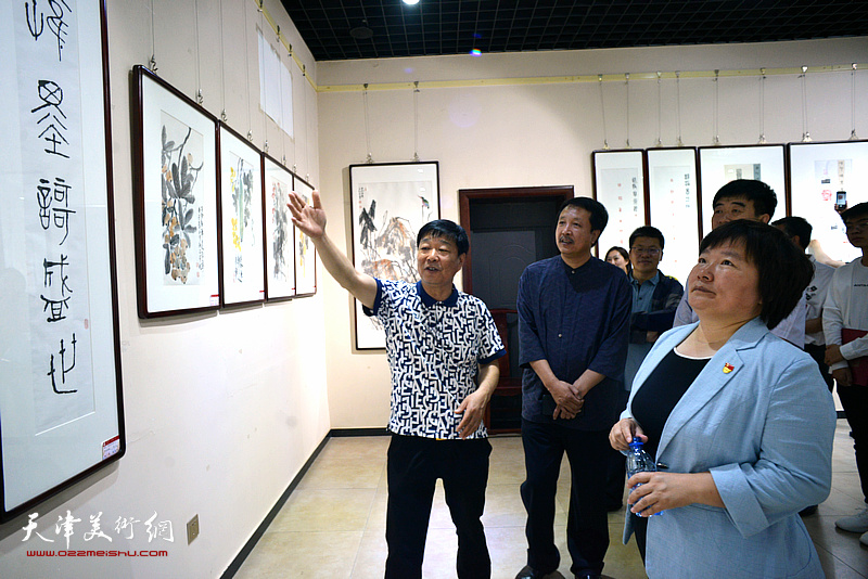 刘洪洋向刘亚秀介绍展出的作品.