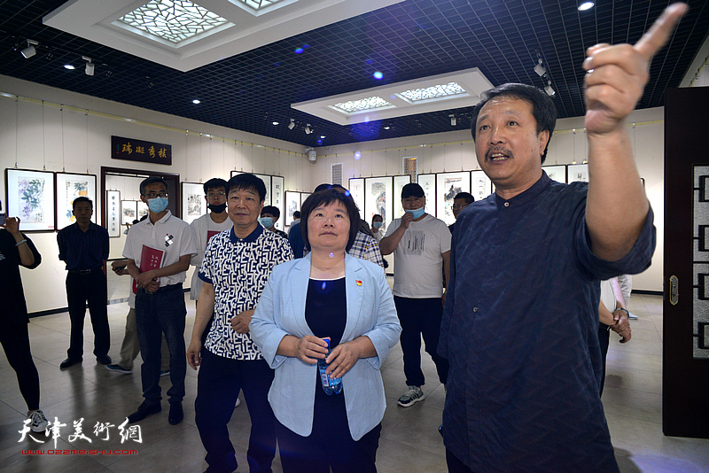 赵振章向刘亚秀介绍展出的作品.